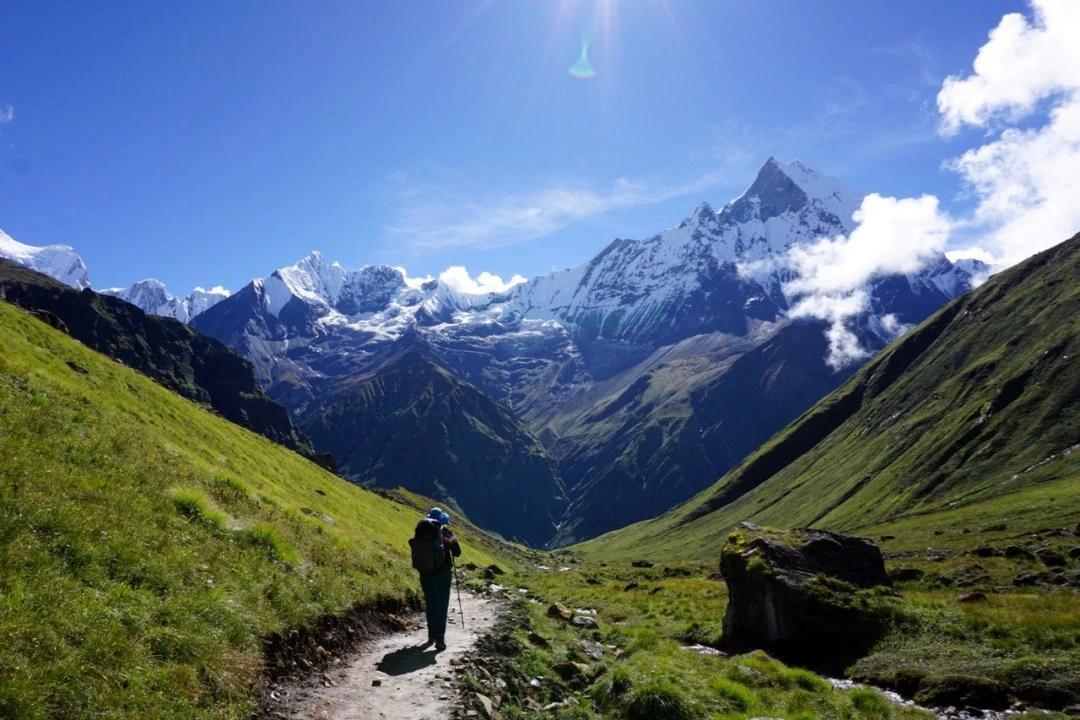 A trekker trekking in Nepal in monsoon seaosn with beautiful mountain view and greenary